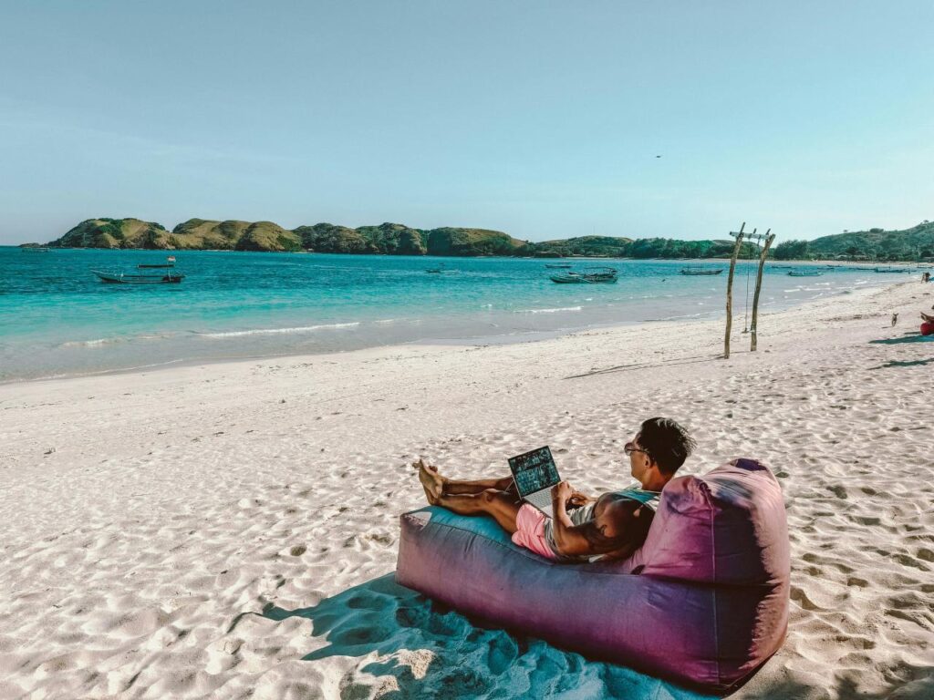 a man sitting on a bean bag on the beach