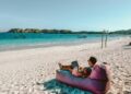 a man sitting on a bean bag on the beach