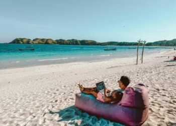 a man sitting on a bean bag on the beach