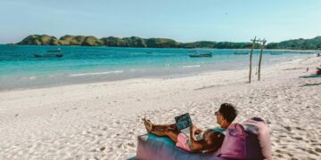 a man sitting on a bean bag on the beach