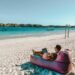 a man sitting on a bean bag on the beach
