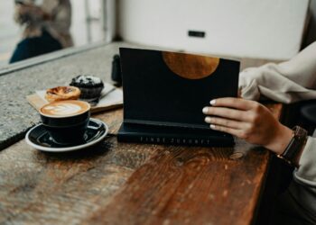 a woman sitting at a table using a laptop computer