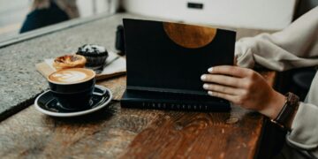 a woman sitting at a table using a laptop computer